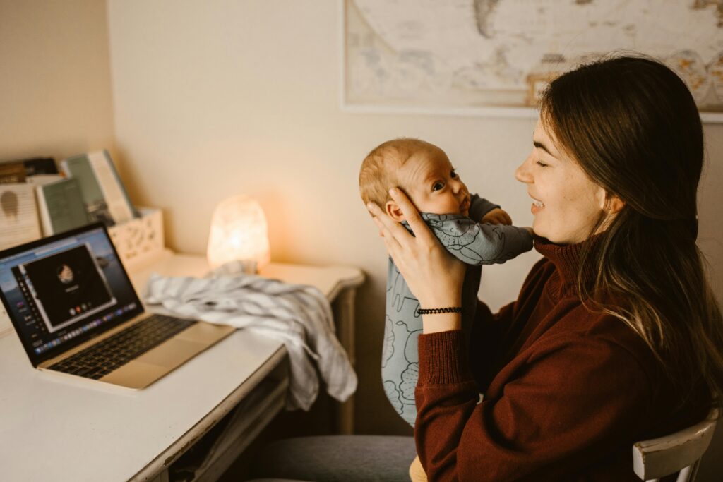 Madre sosteniendo a su bebé mientras guarda recuerdos digitales del primer año
